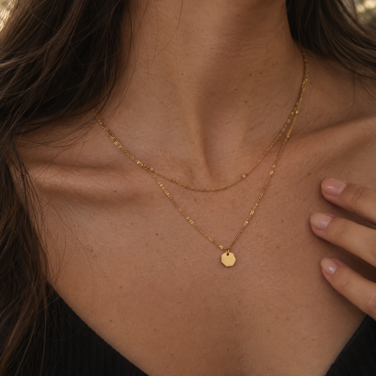 Facet Layer Necklace i guld buren som lager på halsen med liten facetterad berlock.
