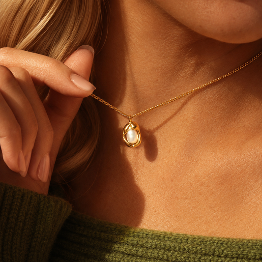 Oyster Necklace 316-kirurginteräksestä, 18K PVD-kultapinnoitteella, lähikuva kullanvärisestä kaulakorusta helmiyksityiskohdalla kaulalla.