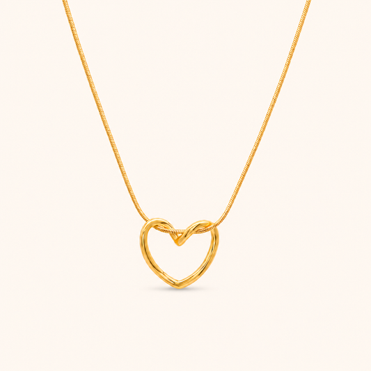 Echo Necklace i 18k PVD-guld med öppet hjärtformat hänge och snake chain på ljus bakgrund.