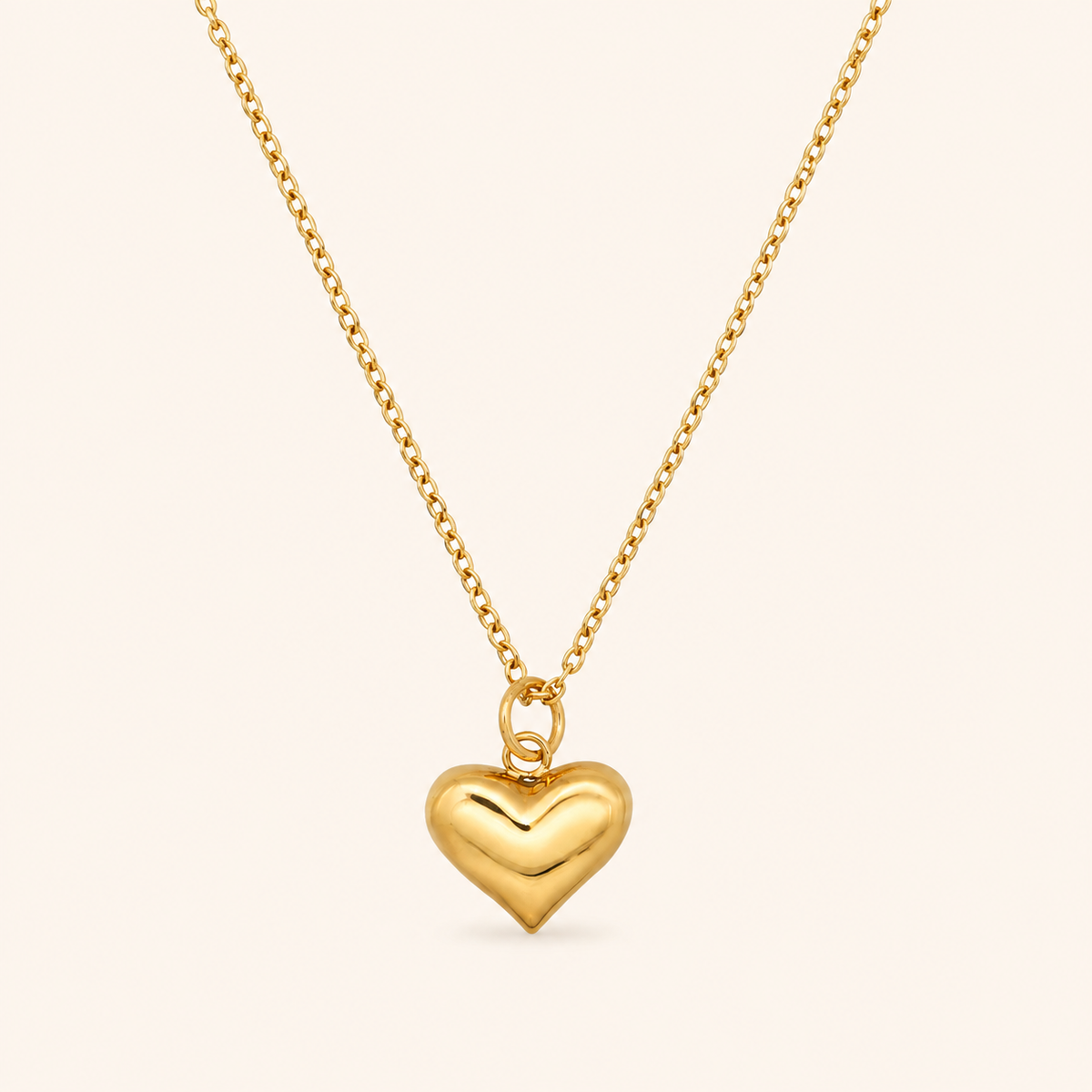 Pulse Necklace 18K PVD-kullalla ja täyteläisellä sydänriipuksella vaalealla taustalla.